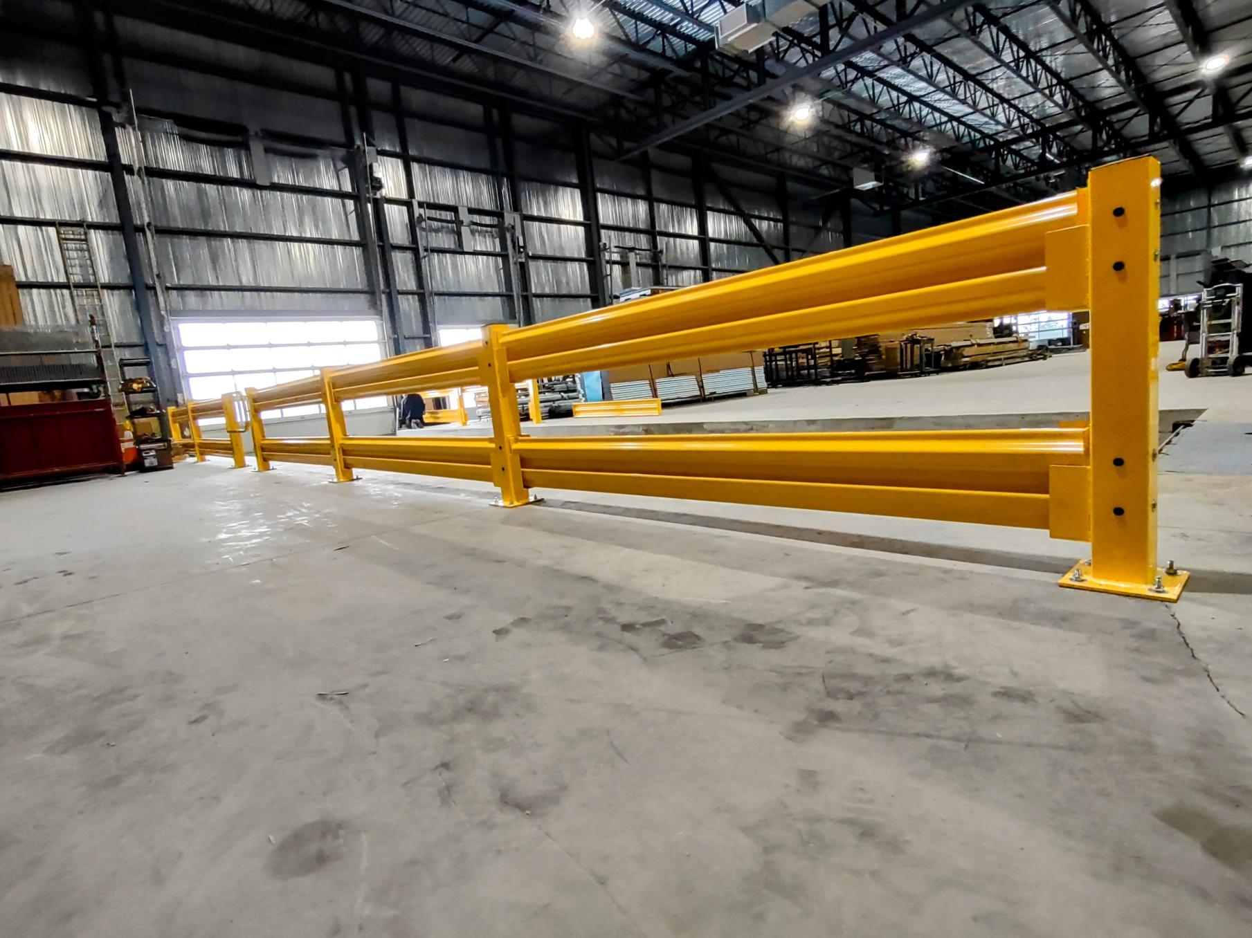 Garde-corps industriel jaune installé dans un entrepôt pour protéger les zones de circulation et les équipements