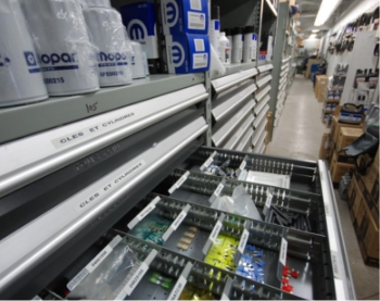 Industrial storage workstation with metal drawers organized for small parts and components in a warehouse or workshop.