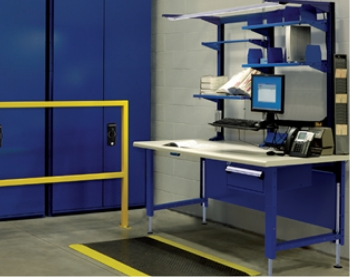 ndustrial workstation with computer, adjustable shelves and durable work surface for warehouse and packaging operations.