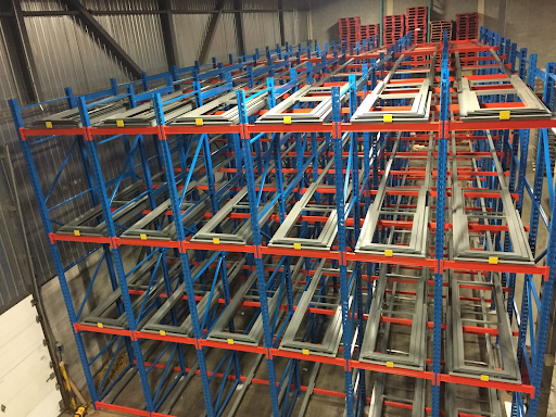 push back racking systems - Pedlex Push back racking system with gravity-fed carts for high-density pallet storage in a warehouse.