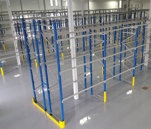 Newly installed warehouse racking system with empty blue and grey frames on polished concrete flooring