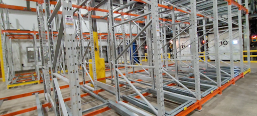 Palette chargée sur un palettier à gravité inversée dans un entrepôt industriel, système push-back avec rail et chariot pour stockage haute densité