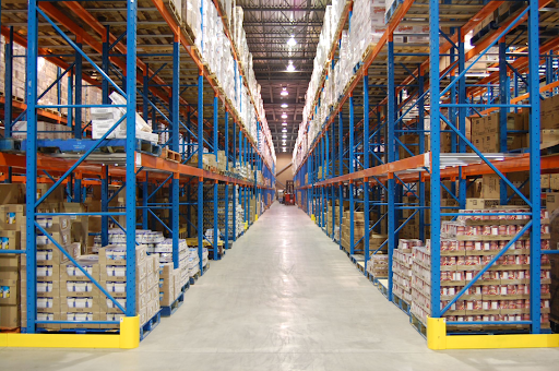 Allée d’entrepôt équipée de palettiers statiques à haute densité pour l’entreposage de palettes en grande quantité.